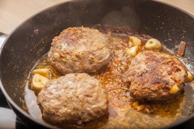 Üç et burger patates bir tavada