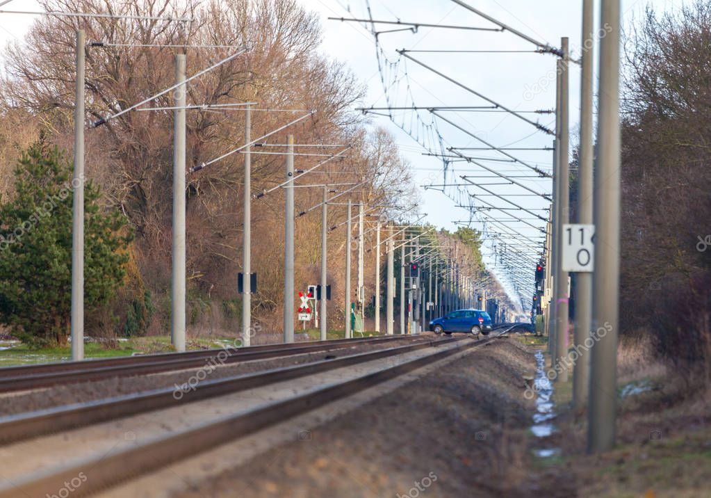 blue car drives over a railroad crossing