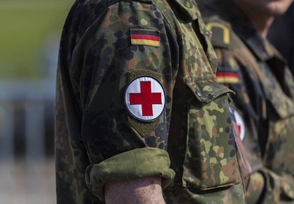 two german army soldiers with a red cross brassard