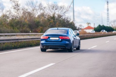 bir Alman karayolu üzerinde mavi araba kullanıyor