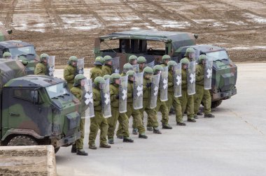 Alman askeri polis asker bir alan rol yapma göstericilere karşı savunur
