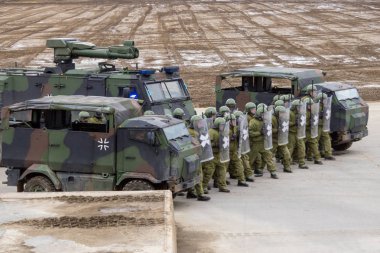Alman askeri polis asker bir alan rol yapma göstericilere karşı savunur