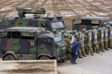 Alman askeri polis asker bir alan rol yapma göstericilere karşı savunur