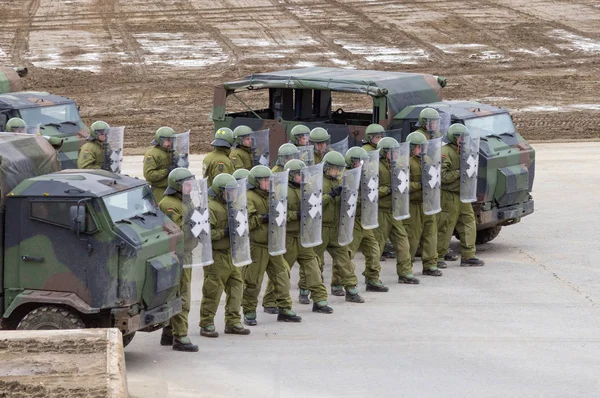 Alman askeri polis asker bir alan rol yapma göstericilere karşı savunur