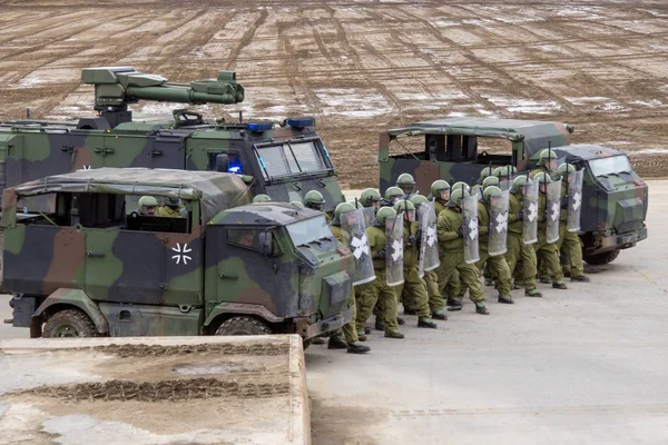 Alman askeri polis asker bir alan rol yapma göstericilere karşı savunur