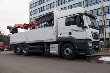 Nuernberg / Almanya - 4 Mart 2018: adam flatbed kamyon vinç ile standları bir sanayi bölgesi yol kenarı üzerinde.