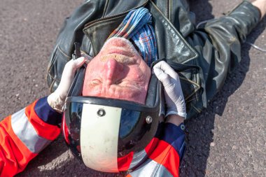 Alman sağlık görevlisi bir kask yaralı bir bisikletçinin kaldırır. Rettungsdienst ambulans servisine Alman bir kelimedir.