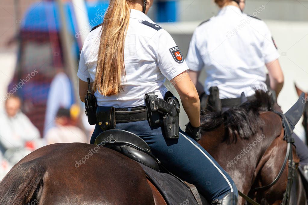 German police horsewoman rides on a police horse. The german word Polizei means police.