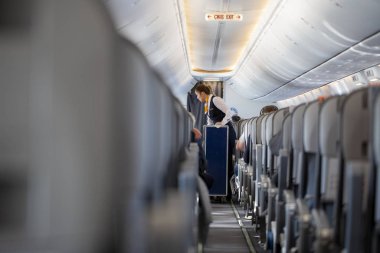 Antalya / Türkiye - 24 Ocak 2020: Airlines Sunexpress hostesi, yolcu kabininden bir servis arabasıyla geçiyor.