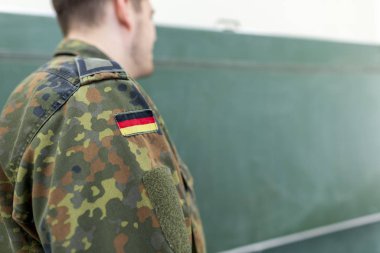 Alman askeri bir sınıfta duruyor. Almanca Bundeswehr, Alman ordusu demek..