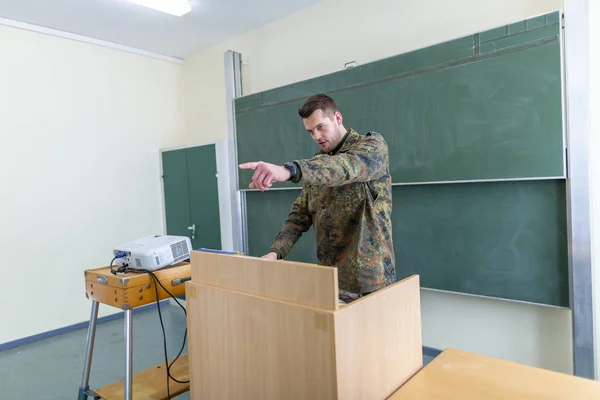 German soldier stands in a classroom . German word Bundeswehr, means german army.