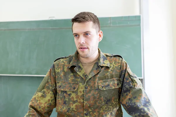 German soldier stands in a classroom . German word Bundeswehr, means german army.