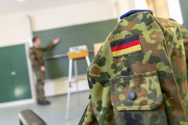 German soldier stands in a classroom . German word Bundeswehr, means german army.