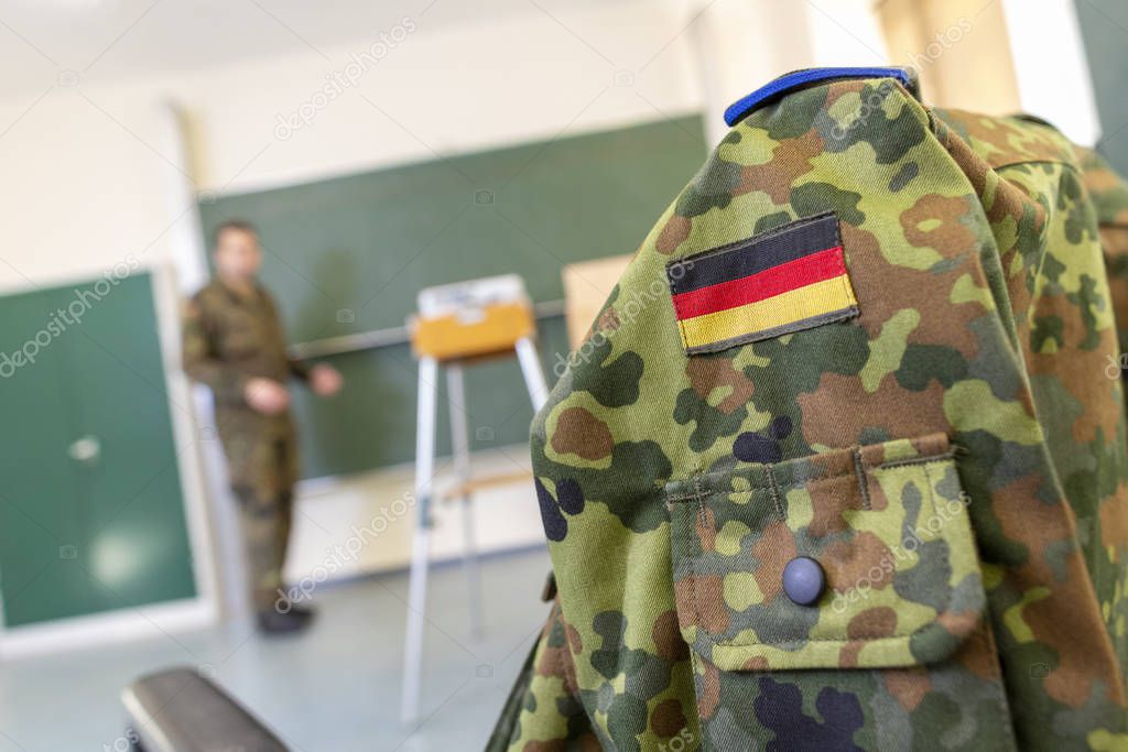 German soldier stands in a classroom . German word Bundeswehr, means german army.
