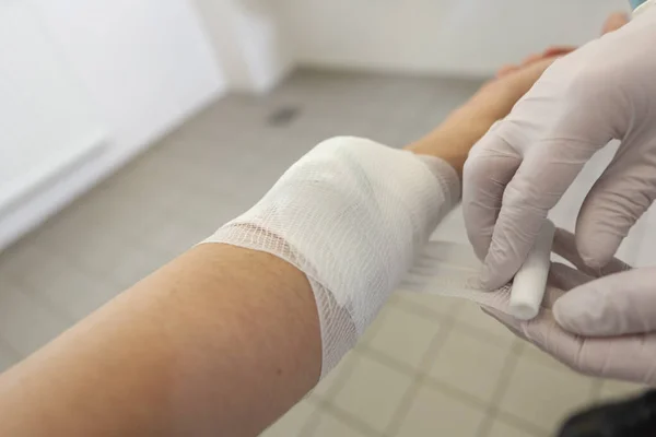A doctor puts on a pressure bandage in a hospital