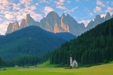 San Giovanni Church in front of dolomites mountain peaks in Santa Magdalena Italy. clipart