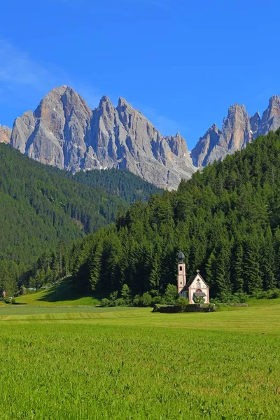 Iglesia de San Giovanni frente a los picos de montaña de dolomitas en Santa Magdalena Italia . — Foto de Stock