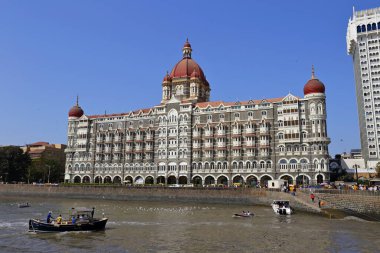 MUMBAI, INDIA - February 7, 2019: A view of the Taj Palace hotel in front of the promenade in Mumbai, India. clipart