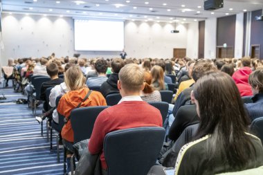 Geniş bir konferans odasında gerçekleşen bir konferans görüntüsü, genç profesyoneller için atölye çalışması, büyük bir konferans salonunda eğitim, yetişkin eğitimi