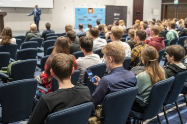 Geniş bir konferans odasında gerçekleşen bir konferans görüntüsü, genç profesyoneller için atölye çalışması, büyük bir konferans salonunda eğitim, yetişkin eğitimi