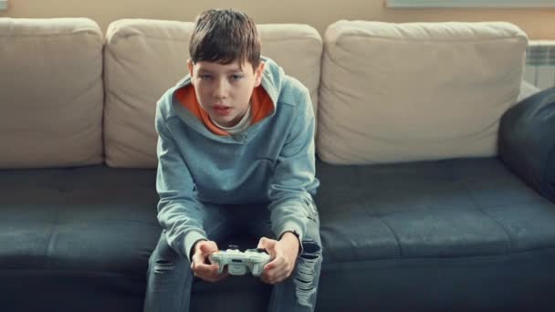 Jeune pré adolescent garçon joue console de jeu vidéo, amusez-vous, rire, tenir le joystick , — Video