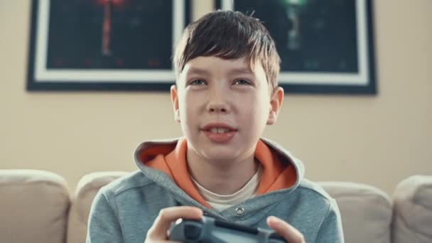 Young pre teenage boy is playing video game console, have fun, laugh, hold the joystick, — Stock Video