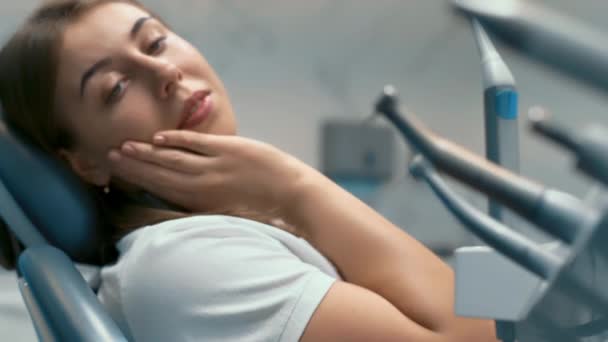 Woman patient in dental clinic. Waiting in dental chair for professional doctor stomatologist. Dental equipment on background. — Stock Video