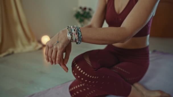 Hübsche Yogalehrerin demonstriert Körperdrehungen, Dehnung und Entspannung mit den Händen auf den Knien und Atmung. — Stockvideo