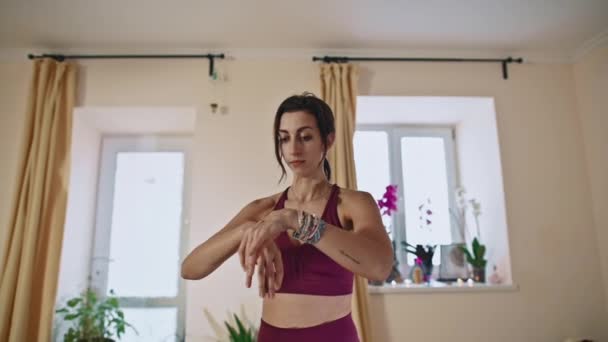 Güzel kadın yoga hocası vücut büküyor, esniyor sonra dizlerinin üstüne çöküp nefes alıyor.. — Stok video
