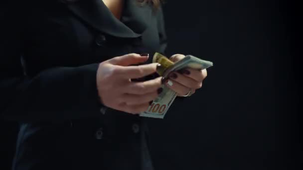 Närbild, ung kvinna affärsman räknar pengar, på svart bakgrund. 4k — Stockvideo