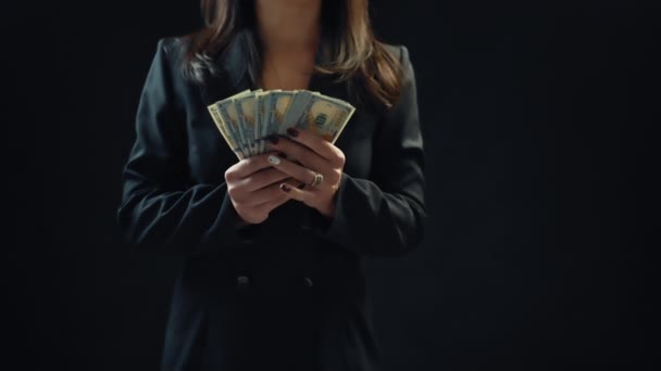 Close up, young woman businessman spreads money, on black background. 4k — Stock Video