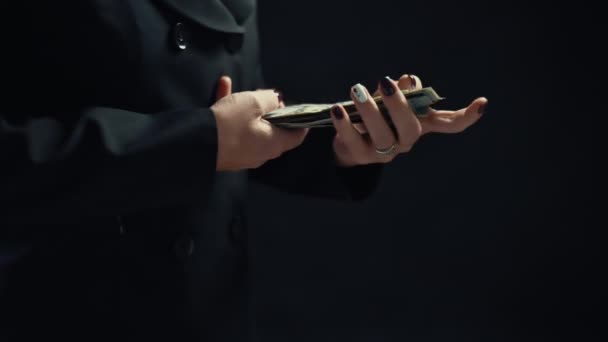 De cerca, una joven empresaria está contando dinero, con un fondo negro. 4k — Vídeo de stock