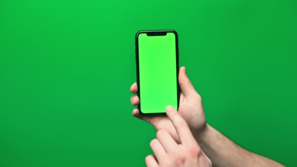 Telefone na mão isolado em um fundo verde. Tela do telefone - chave de croma verde, fundo chave de croma verde. Quadros para publicidade móvel, promos . — Vídeo de Stock