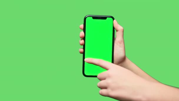 Phone in hand isolated on a green background. Phone screen - green chroma key, background green chroma key. Frames for mobile advertising, promos. — Stock Video