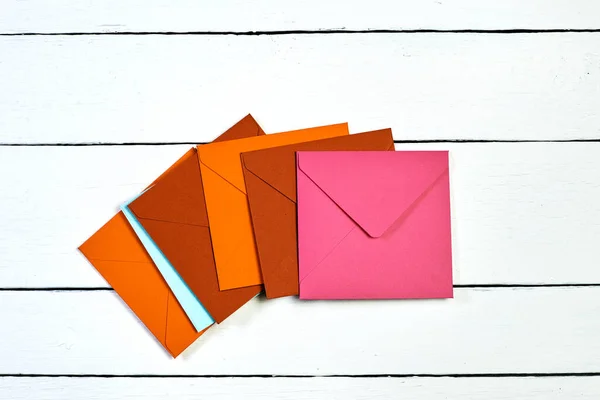 Зображення верхнього виду різнокольорових конвертів на білому дерев'яному столі . — стокове фото