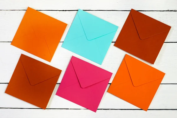 Image of a top view of multi-colored envelopes on a white wooden table. — Stock Photo, Image