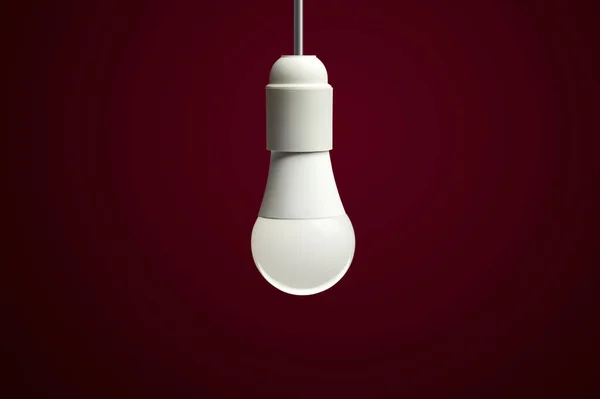 LED enerji tasarrufu ampulü. Işık yayan diyodeon kırmızı arkaplan