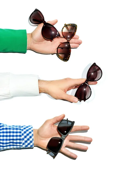 Mužské ruce drží sluneční brýle na bílém pozadí. Natáčení ve studiu. — Stock fotografie