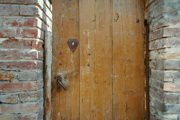 Forntida trädörr i gammal sten slott vägg. — Stockfoto