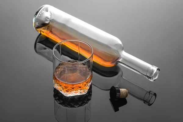 Whiskey wlewana do szklanki na szarym tle, zimna atmosfera, czas na relaks z whisky. — Zdjęcie stockowe