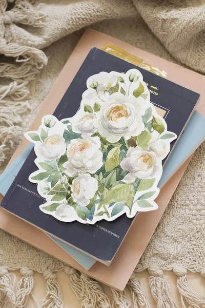 Flor de rosas de jardim pintado com aquarela, pincel, ao redor dos livros e chá. Vista aérea. Deitado plano, vista superior . — Fotografia de Stock