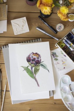 Çalışma alanı. Sulu boya, boya fırçası, mumlar ve beyaz arka plan üzerinde izole şişe ile egzotik çiçek boyalı. Havai görünümü. Düz yatıyordu, en iyi görünümü.