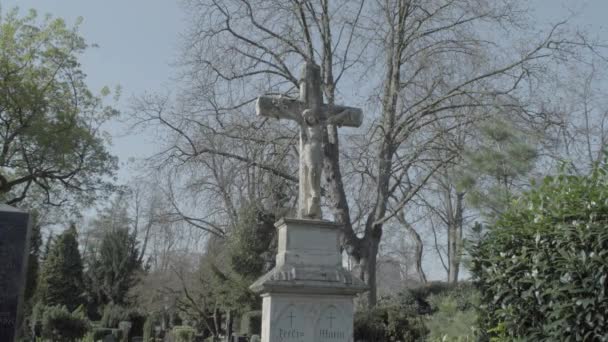 Antigua lápida con la cruz de Jesús en un soleado día de primavera. Inclinado de la lápida al cielo. 4K en SLOG3. Largo plazo . — Vídeo de stock