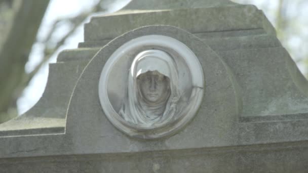 Vieille pierre tombale du 19ème siècle par une journée ensoleillée de printemps. Se déconcentrer d'une sculpture de madone. 4K en SLOG3. Gros plan . — Video