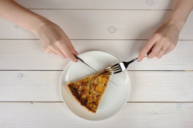 Beyaz bir plaka üzerinde bir dilim pasta kesme eller. Üstten Görünüm