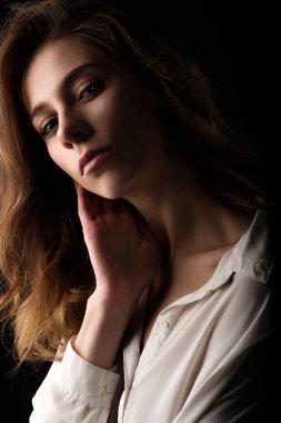 Stüdyo portre siyah arka plan üzerine beyaz bluz içinde genç kadın kapatmak