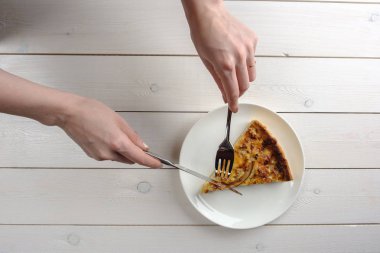 Beyaz bir plaka üzerinde bir dilim pasta kesme eller. Üstten Görünüm