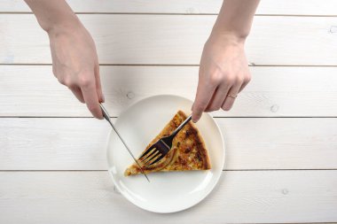 Beyaz bir plaka üzerinde bir dilim pasta kesme eller. Üstten Görünüm