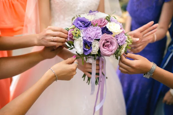 Bruidsmeisjes houden een bruiloft boeket — Stockfoto