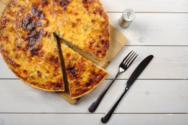 Pasta ahşap tahta üzerinde beyaz bir masanın üzerinde yatan çatal bıçak ile kesme. Üstten Görünüm